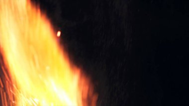 Şenlik ateşi kıvılcımlarının Macro fotoğrafı. Alevler patlar, patlamalar. Patlama mikro parlaklığı. Mini Havai fişekler. Kırmızı kamerada çekim hala siyah arkaplanda. Güzel sızıntılar kıvılcım posteri, afiş, duvar kağıdı, arkaplan, doku.