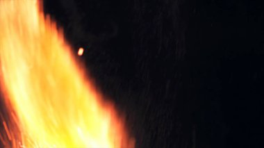 Şenlik ateşi kıvılcımlarının Macro fotoğrafı. Alevler patlar, patlamalar. Patlama mikro parlaklığı. Mini Havai fişekler. Kırmızı kamerada çekim hala siyah arkaplanda. Güzel sızıntılar kıvılcım posteri, afiş, duvar kağıdı, arkaplan, doku.