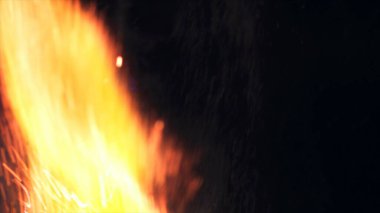 Şenlik ateşi kıvılcımlarının Macro fotoğrafı. Alevler patlar, patlamalar. Patlama mikro parlaklığı. Mini Havai fişekler. Kırmızı kamerada çekim hala siyah arkaplanda. Güzel sızıntılar kıvılcım posteri, afiş, duvar kağıdı, arkaplan, doku.