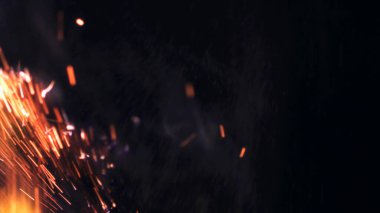 Şenlik ateşi kıvılcımlarının Macro fotoğrafı. Alevler patlar, patlamalar. Patlama mikro parlaklığı. Mini Havai fişekler. Kırmızı kamerada çekim hala siyah arkaplanda. Güzel sızıntılar kıvılcım posteri, afiş, duvar kağıdı, arkaplan, doku.
