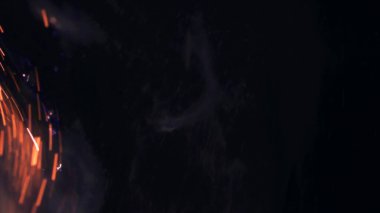 Şenlik ateşi kıvılcımlarının Macro fotoğrafı. Alevler patlar, patlamalar. Patlama mikro parlaklığı. Mini Havai fişekler. Kırmızı kamerada çekim hala siyah arkaplanda. Güzel sızıntılar kıvılcım posteri, afiş, duvar kağıdı, arkaplan, doku.