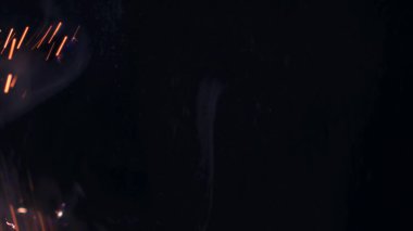 Şenlik ateşi kıvılcımlarının Macro fotoğrafı. Alevler patlar, patlamalar. Patlama mikro parlaklığı. Mini Havai fişekler. Kırmızı kamerada çekim hala siyah arkaplanda. Güzel sızıntılar kıvılcım posteri, afiş, duvar kağıdı, arkaplan, doku.