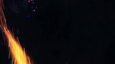Şenlik ateşi kıvılcımlarının Macro fotoğrafı. Alevler patlar, patlamalar. Patlama mikro parlaklığı. Mini Havai fişekler. Kırmızı kamerada çekim hala siyah arkaplanda. Güzel sızıntılar kıvılcım posteri, afiş, duvar kağıdı, arkaplan, doku.
