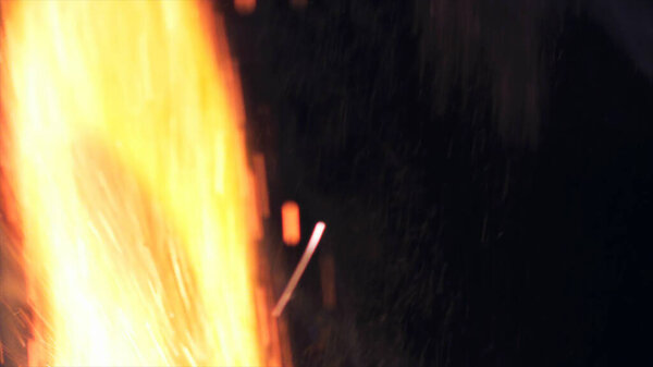 Макрофотография искр костра. Огненное пламя взрывается, взрывается. Взрывной микро блеск. Мини фейерверк. Стрельба на красной камере все еще на черном фоне. Выщелачивание накладывает искру на плакат, баннер, обои, подложку, текстуру.