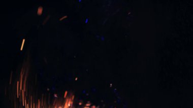 Şenlik ateşi kıvılcımlarının Macro fotoğrafı. Alevler patlar, patlamalar. Patlama mikro parlaklığı. Mini Havai fişekler. Kırmızı kamerada çekim hala siyah arkaplanda. Güzel sızıntılar kıvılcım posteri, afiş, duvar kağıdı, arkaplan, doku.