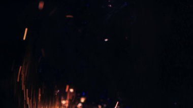 Şenlik ateşi kıvılcımlarının Macro fotoğrafı. Alevler patlar, patlamalar. Patlama mikro parlaklığı. Mini Havai fişekler. Kırmızı kamerada çekim hala siyah arkaplanda. Güzel sızıntılar kıvılcım posteri, afiş, duvar kağıdı, arkaplan, doku.