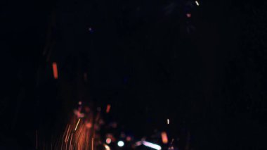 Şenlik ateşi kıvılcımlarının Macro fotoğrafı. Alevler patlar, patlamalar. Patlama mikro parlaklığı. Mini Havai fişekler. Kırmızı kamerada çekim hala siyah arkaplanda. Güzel sızıntılar kıvılcım posteri, afiş, duvar kağıdı, arkaplan, doku.