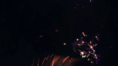 Şenlik ateşi kıvılcımlarının Macro fotoğrafı. Alevler patlar, patlamalar. Patlama mikro parlaklığı. Mini Havai fişekler. Kırmızı kamerada çekim hala siyah arkaplanda. Güzel sızıntılar kıvılcım posteri, afiş, duvar kağıdı, arkaplan, doku.
