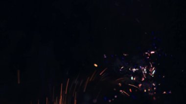 Şenlik ateşi kıvılcımlarının Macro fotoğrafı. Alevler patlar, patlamalar. Patlama mikro parlaklığı. Mini Havai fişekler. Kırmızı kamerada çekim hala siyah arkaplanda. Güzel sızıntılar kıvılcım posteri, afiş, duvar kağıdı, arkaplan, doku.