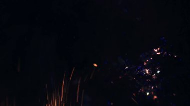 Şenlik ateşi kıvılcımlarının Macro fotoğrafı. Alevler patlar, patlamalar. Patlama mikro parlaklığı. Mini Havai fişekler. Kırmızı kamerada çekim hala siyah arkaplanda. Güzel sızıntılar kıvılcım posteri, afiş, duvar kağıdı, arkaplan, doku.