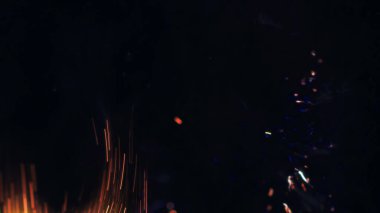 Şenlik ateşi kıvılcımlarının Macro fotoğrafı. Alevler patlar, patlamalar. Patlama mikro parlaklığı. Mini Havai fişekler. Kırmızı kamerada çekim hala siyah arkaplanda. Güzel sızıntılar kıvılcım posteri, afiş, duvar kağıdı, arkaplan, doku.