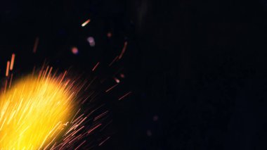 Şenlik ateşi kıvılcımlarının Macro fotoğrafı. Alevler patlar, patlamalar. Patlama mikro parlaklığı. Mini Havai fişekler. Kırmızı kamerada çekim hala siyah arkaplanda. Güzel sızıntılar kıvılcım posteri, afiş, duvar kağıdı, arkaplan, doku.