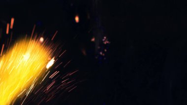 Şenlik ateşi kıvılcımlarının Macro fotoğrafı. Alevler patlar, patlamalar. Patlama mikro parlaklığı. Mini Havai fişekler. Kırmızı kamerada çekim hala siyah arkaplanda. Güzel sızıntılar kıvılcım posteri, afiş, duvar kağıdı, arkaplan, doku.