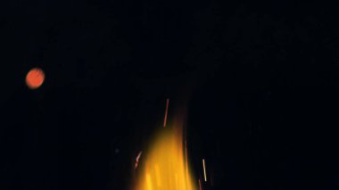 Şenlik ateşi kıvılcımlarının Macro fotoğrafı. Alevler patlar, patlamalar. Patlama mikro parlaklığı. Mini Havai fişekler. Kırmızı kamerada çekim hala siyah arkaplanda. Güzel sızıntılar kıvılcım posteri, afiş, duvar kağıdı, arkaplan, doku.