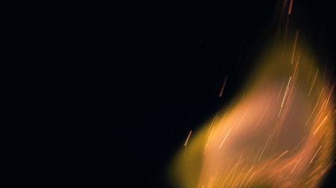 Şenlik ateşi kıvılcımlarının Macro fotoğrafı. Alevler patlar, patlamalar. Patlama mikro parlaklığı. Mini Havai fişekler. Kırmızı kamerada çekim hala siyah arkaplanda. Güzel sızıntılar kıvılcım posteri, afiş, duvar kağıdı, arkaplan, doku.
