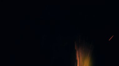 Şenlik ateşi kıvılcımlarının Macro fotoğrafı. Alevler patlar, patlamalar. Patlama mikro parlaklığı. Mini Havai fişekler. Kırmızı kamerada çekim hala siyah arkaplanda. Güzel sızıntılar kıvılcım saçar.