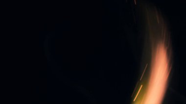 Şenlik ateşi kıvılcımlarının Macro fotoğrafı. Alevler patlar, patlamalar. Patlama mikro parlaklığı. Mini Havai fişekler. Kırmızı kamerada çekim hala siyah arkaplanda. Güzel sızıntılar kıvılcım saçar.