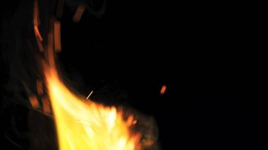 Şenlik ateşi kıvılcımlarının Macro fotoğrafı. Alevler patlar, patlamalar. Patlama mikro parlaklığı. Mini Havai fişekler. Kırmızı kamerada çekim hala siyah arkaplanda. Güzel sızıntılar kıvılcım posteri, afiş, duvar kağıdı, arkaplan, doku.