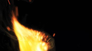 Şenlik ateşi kıvılcımlarının Macro fotoğrafı. Alevler patlar, patlamalar. Patlama mikro parlaklığı. Mini Havai fişekler. Kırmızı kamerada çekim hala siyah arkaplanda. Güzel sızıntılar kıvılcım posteri, afiş, duvar kağıdı, arkaplan, doku.