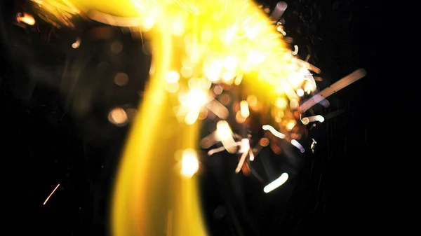 Macro photo of Bonfire sparks. Fire Flames bursts, blasts. Explosion micro sparkles. Mini Fireworks. Shooting on Red camera still on black background. Beautiful leaks overlay spark poster, banner, wallpaper, backdrop, texture.