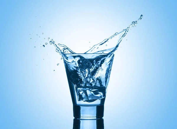 Wasser und Spritzer auf blauem Hintergrund. — Stockfoto