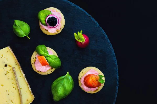 Canapés de panqueque caseros y queso en el plato de piedra de pizarra para la fiesta de alimentos para los dedos —  Fotos de Stock