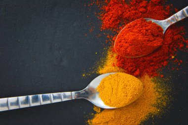 Kara barut tahta kaşık içinde çeşitli baharatlar (köri ve kırmızı biber)