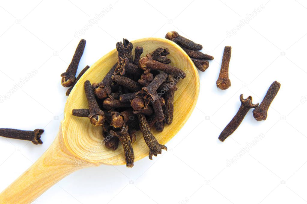 Dry cloves herbs in bamboo spoon isolates on white background
