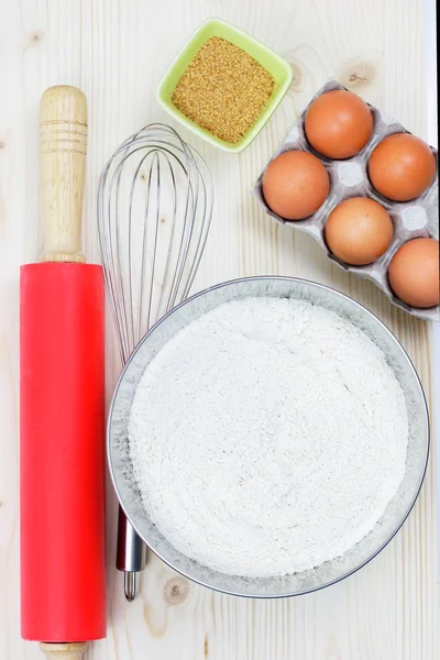 ingredients and tools to make a bakery, flour in blow, sugar, eggs