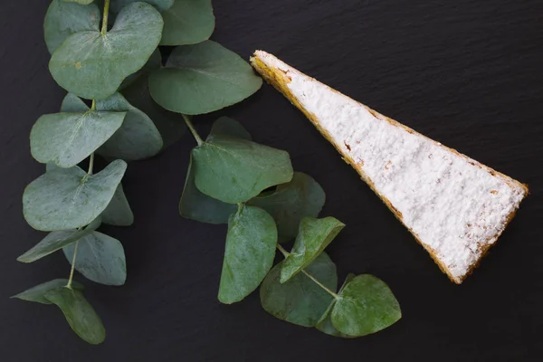 Classica torta di strato di pralina bianca francese decorare da foglie classiche su piatto di pietra di ardesia nera — Foto Stock