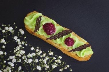 Ahududu ve çikolata tarafından klasik Fransız fıstıklı pasta dekor süslemeleri beyaz Eustoma tarafından siyah arduvaz taş plaka üzerinde 