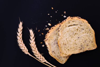 Kopya alanı siyah zemin üzerine kepekli tahıllar organik tam buğday ekmek