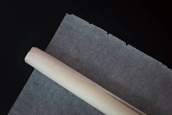 Nástroj nebo příslušenství pergamenový papír kuchyňské pečení listy papíru na černém pozadí — Stock fotografie