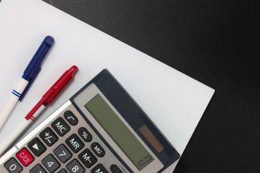 Dali İş Finans planer hesap makinesi, kalem, kopya alanı siyah zemin üzerine beyaz boş kağıtlar 