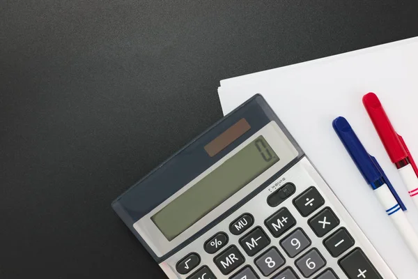 Dali İş Finans planer hesap makinesi, kalem, kopya alanı siyah zemin üzerine beyaz boş kağıtlar 