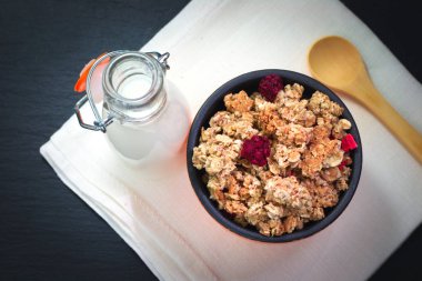 Yemek kahvaltı kavramı organik müsli veya Granola ve siyah arduvaz taş plaka üzerinde peçete ile süt