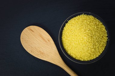 Gıda kavramı kopya alanı ile kayrak taş plaka üzerinde bir kapta ham organik kuskus