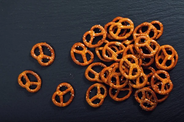 Yemek tuzlu çıtır Pretzel kopya alanı ile siyah arduvaz plaka üzerinde snack