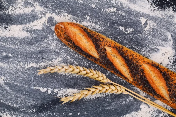 Food background Organic French poppy seeds Baguette on black slate stone plate with copy space