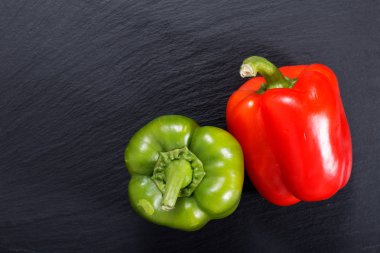 Kopya alanı ile siyah arduvaz taş plaka üzerinde organik kırmızı ve yeşil biber