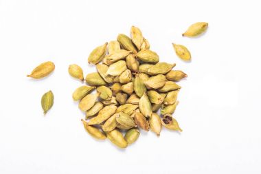 Beyaz arka plan üzerinde egzotik baharatlar kavramı organik kakule bakla