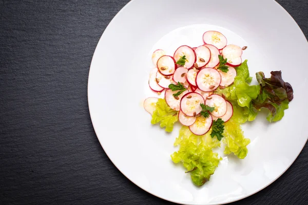 Gesunde Ernährung Bio-Scheiben Rettichsalat in weißem Teller auf schwarzem — Stockfoto