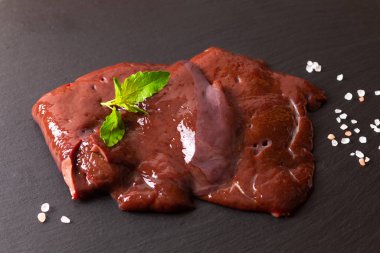 Gıda konsepti Organik Dilimlenmiş taze sığır ciğeri siyah levha b üzerinde
