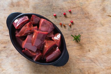 Food concept organic raw beef live in black ceramic cup on woode