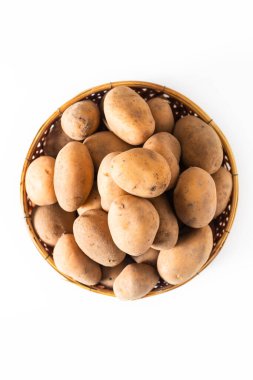 Sağlıklı gıda kavramı, beyaz arka planda izole edilmiş bambu sepetindeki organik çiğ patates.