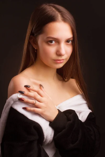 portrait of a brunette girl in the Studio on a plain black backg