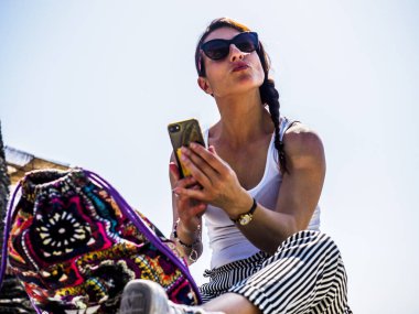 Akıllı telefonlu güzel bir kız, objektiften bakıyor..