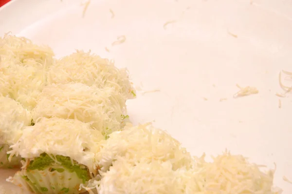 白い皿にすりおろしたチーズのスポンジケーキ — ストック写真