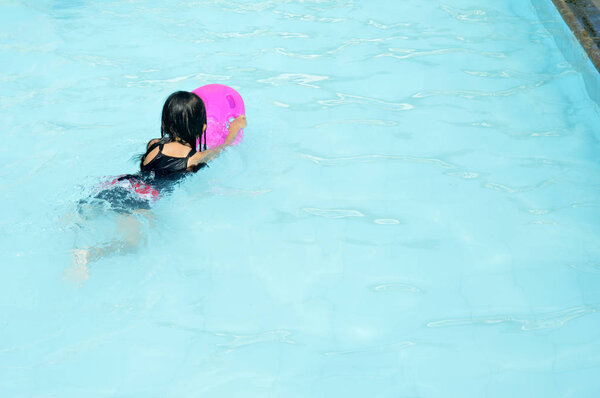 азиатская маленькая девочка играет в бассейне
