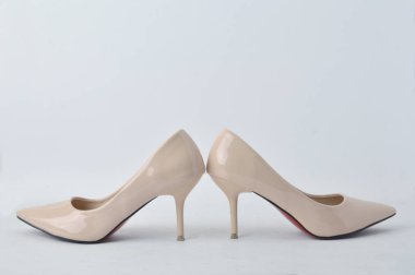 Beyaz arka plan üzerinde bej yüksek topuk ayakkabı